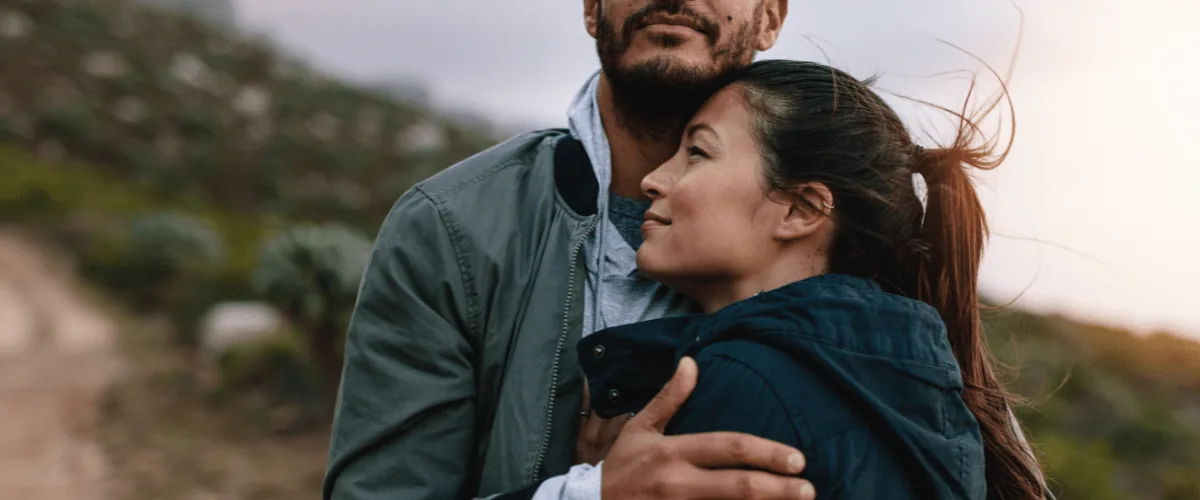 Couple embracing outdoors on a hillside