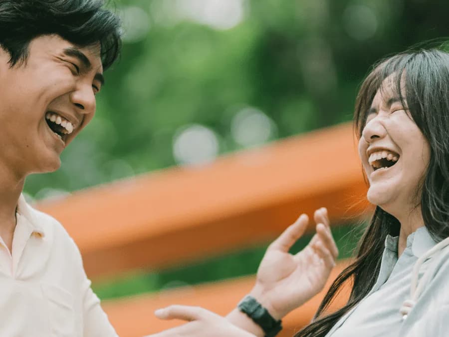 Two people laughing together outdoors
