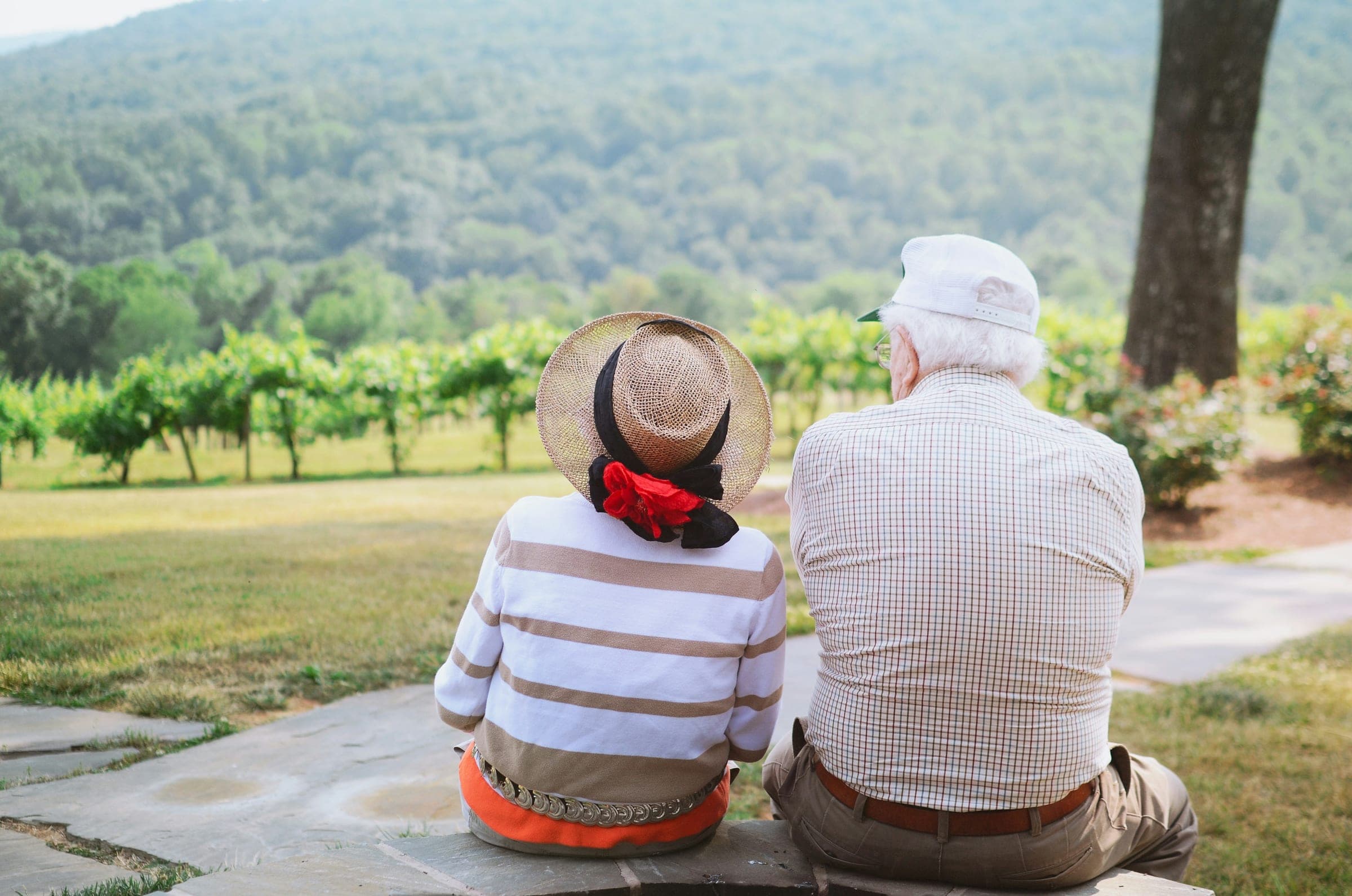 An older couple sitting together outdoors, enjoying time together