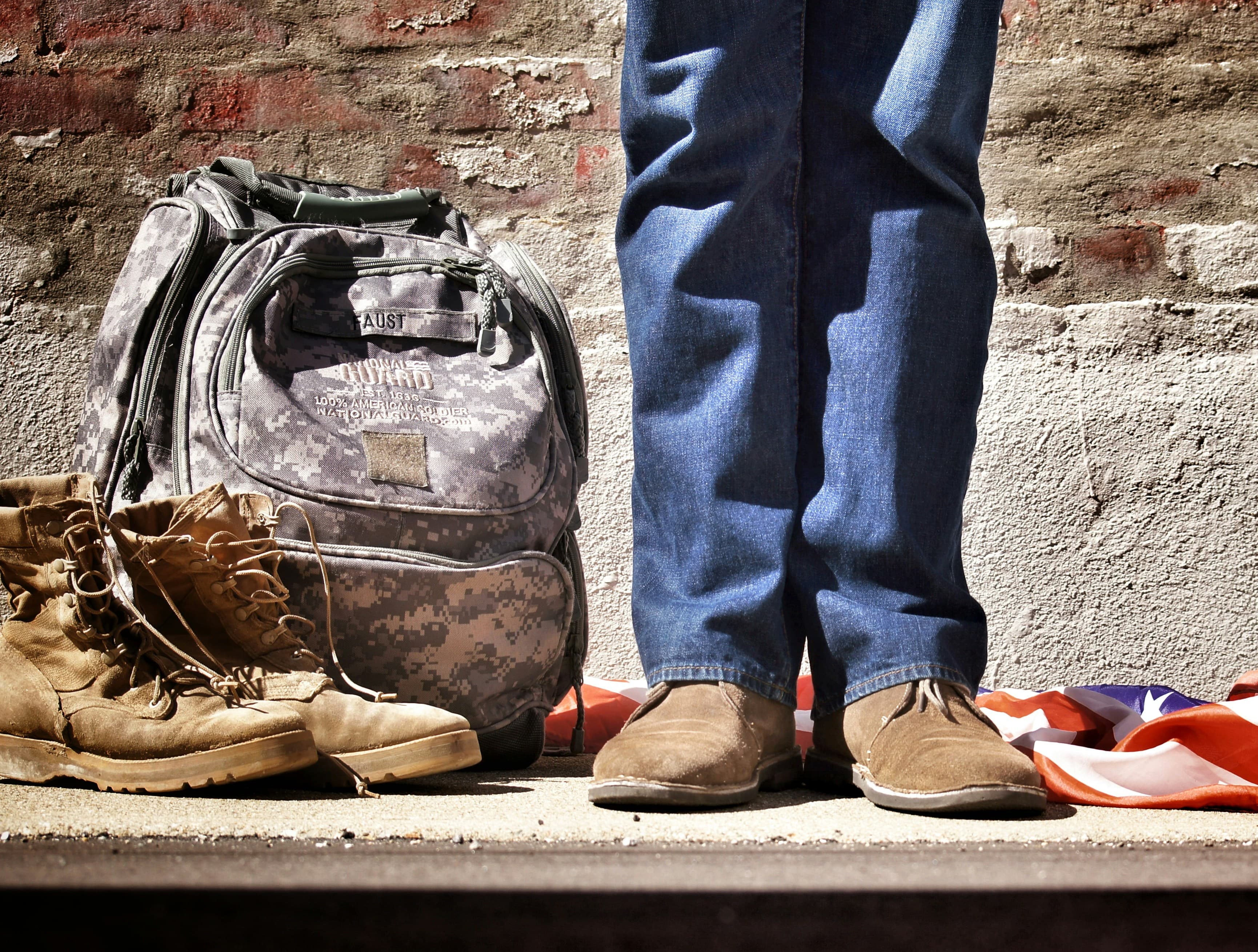 Military boots and a backpack beside an American flag